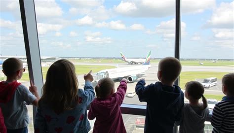kinderen die met verrekijkers op het Panoramaterras vliegtuigen spotten