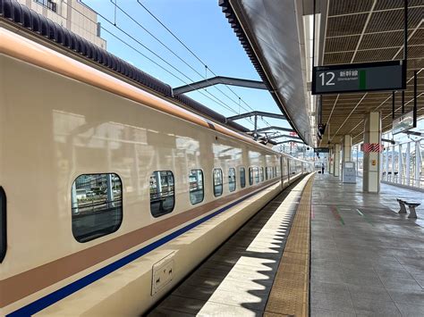 Een witte Shinkansen (bullet train) die door het Japanse landschap rijdt