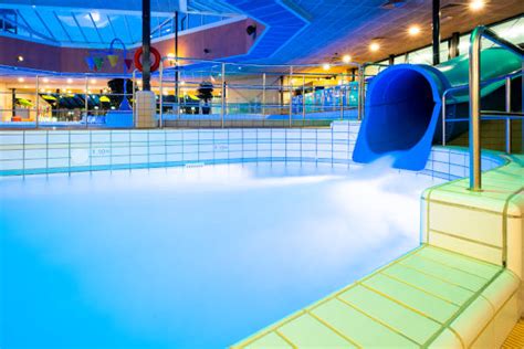 kinderen spelen in een binnenzwembad met glijbaan