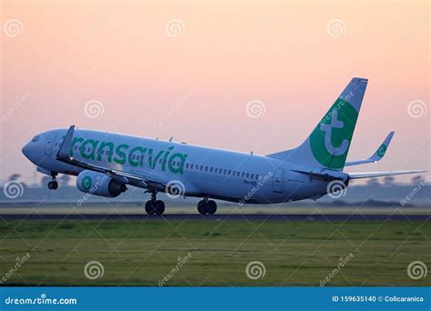 Een Transavia vliegtuig dat opstijgt met de zon op de achtergrond.