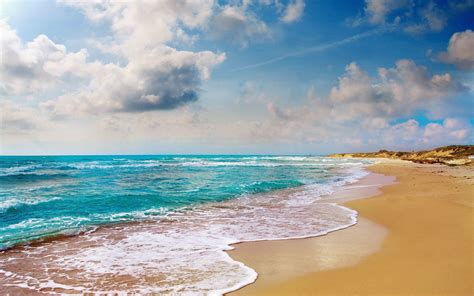 Foto van een zonnig strand en de zee, symboliseert een vakantie