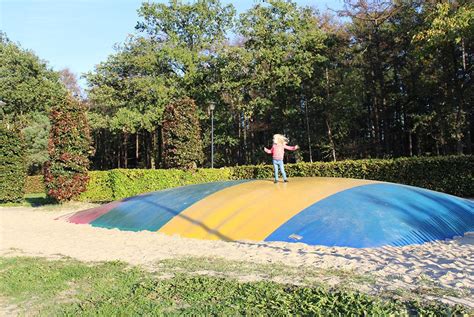 Kinderen spelen in de speeltuin en op de airtrampoline op Landal Amerongse Berg