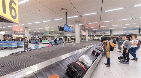 Foto van een bagageband op een drukke luchthaven.
