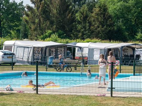 Overzichtsfoto van Camping de Heische Tip met de recreatieplas, speeltuin en terras