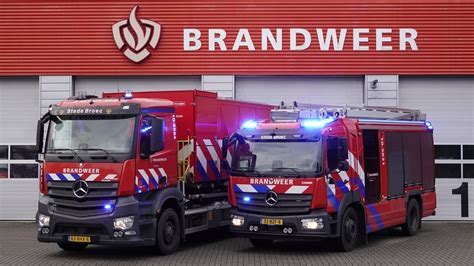 een brandweerwagen bij een brandende hangar op een vliegveld