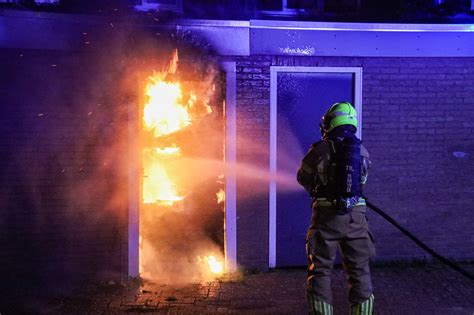 vlammen slaan uit een hangar op een vliegveld