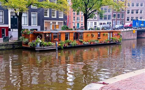 Een sfeervolle foto van een woonboot op een Amsterdamse gracht bij zonsondergang.