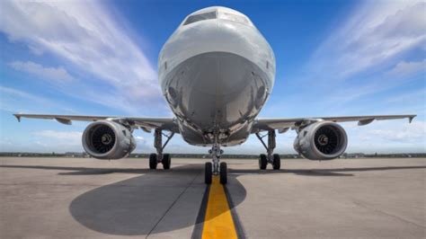 Vliegtuig op de landingsbaan van een eilandluchthaven, met op de achtergrond de oceaan