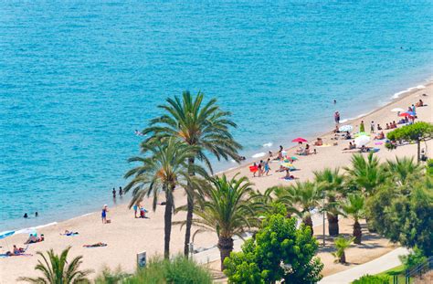 Breed zandstrand van Pineda de Mar met ligbedden en parasols