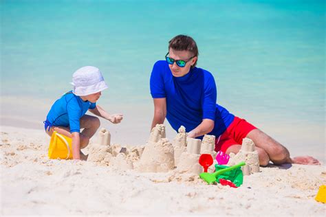 Gezin bouwt zandkastelen op een zonnig strand