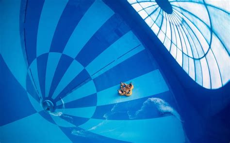 Illustratie van de Aqua Racer bandenglijbaan met gasten in opblaasbanden.