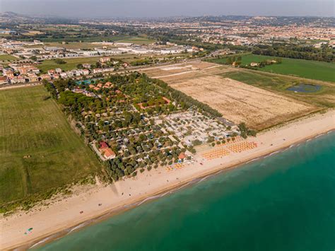 Luchtfoto van La Risacca Family Camping Village met het strand en de zee op de voorgrond.