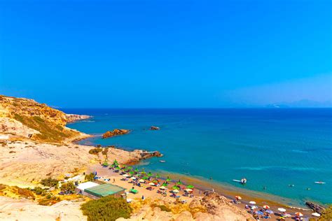 panoramisch uitzicht op een zonnig strand op Kos met turquoise water en parasols