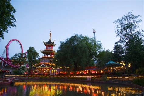 Een sfeervolle foto van Tivoli Gardens versierd met kerstverlichting en kerstbomen.