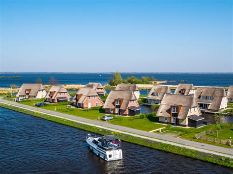 Dronebeelden van Marinapark Tacozijl met chalets aan het water en de Friese Meren op de achtergrond