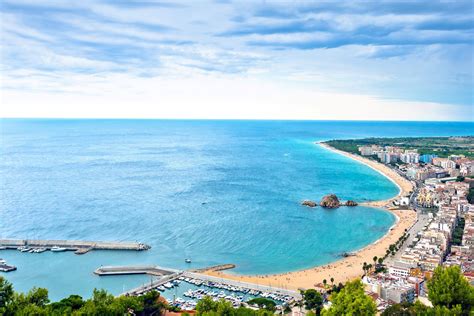 Een panoramisch uitzicht over het brede zandstrand van Santa Susanna met de boulevard en de Middellandse Zee op de achtergrond.