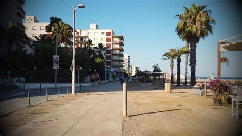 Een sfeervolle avondopname van de boulevard van Santa Susanna met verlichte restaurants en bars aan zee.