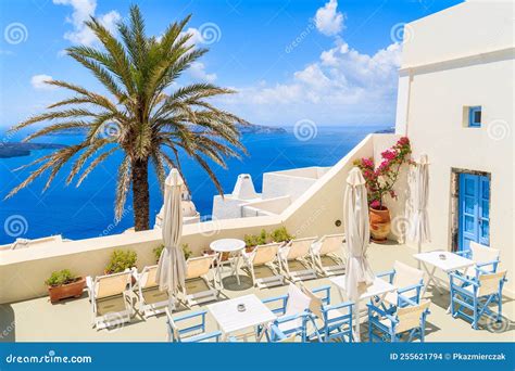 Het terras van Santorini Airport met blauwe stoelen en uitzicht op de landingsbaan