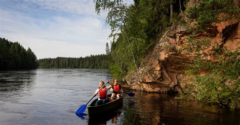 kanovaart op een Finse rivier met dichte bossen op de achtergrond
