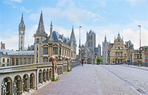 Een panoramisch uitzicht over de historische binnenstad van Gent met de drie torens op de achtergrond.