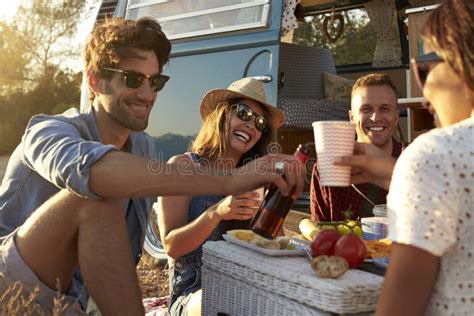Een groep vrienden geniet van een picknick naast hun camper