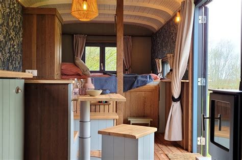 Interieur van een luxe ingerichte pipowagen met comfortabel bed en sfeervolle aankleding