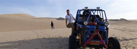 Een sandbuggy die door de hoge zandduinen van Huacachina rijdt.