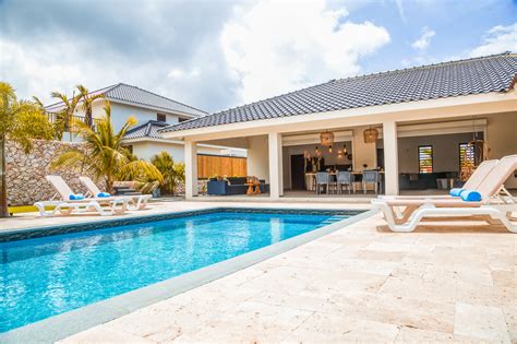 Een gezin geniet van een duik in een privézwembad bij hun vakantiehuis.