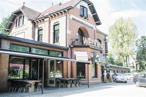 De statige gevel van Parkhotel Hugo de Vries, een Jugendstil villa omringd door groen