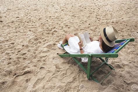 Afbeelding van iemand die ontspannen op een strandstoel zit met gesloten ogen, weg van de felle zon.