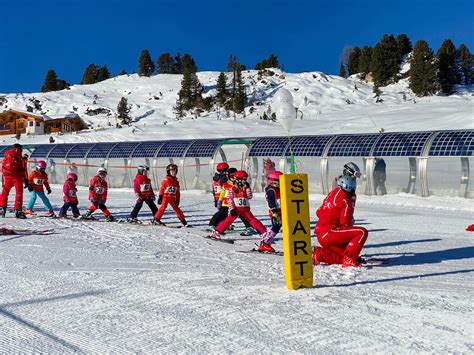 Foto van een skileraar die lesgeeft aan kinderen in de Alpen