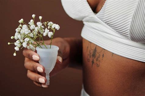 vrouw inpakt handbagage met daarin een menstruatiecup en pijnstillers