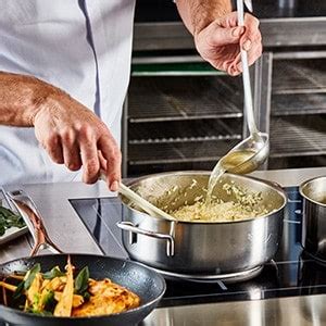 Een typische Australische hostelkeuken met diverse backpackers die maaltijden bereiden.