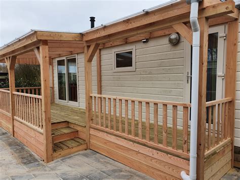 Foto van een stacaravan met een gemeubileerde veranda en parasol