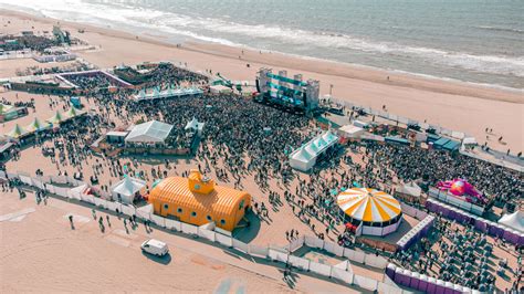 Luchtfoto van de Corendon Beachclub in Zandvoort met ligbedden en parasols aan zee