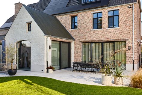 Minimaal ingerichte woonkamer met grote ramen die uitkijken op groen, landelijk huis Mas Prats.