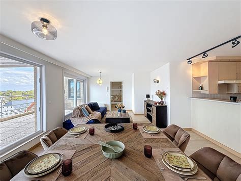 Ruim appartement met glazen eetkamer en uitzicht op zee en zwembad.