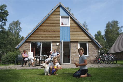 Gezin met hond genietend op het terras van een vakantiehuisje.