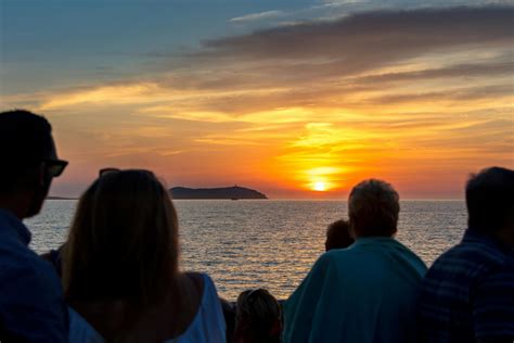 Groep jongeren op een boot bij zonsondergang