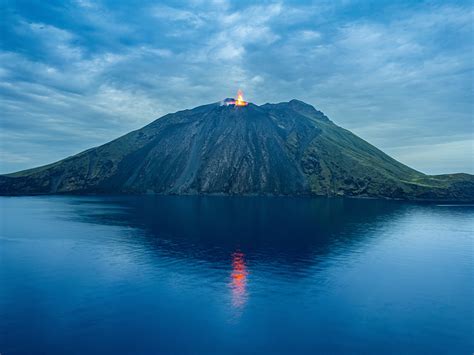 Foto van het zwarte lavastrand van Stromboli met de vulkaan op de achtergrond