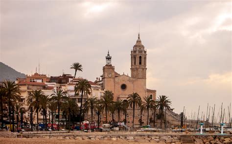 panoramisch uitzicht over de boulevard van Sitges met de kerk Sant Bartomeu i Santa Tecla op de achtergrond