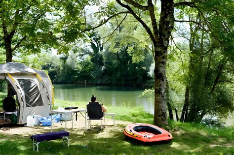 Een sfeerbeeld van Camping Solaire, met schaduwrijke plekken onder hoge bomen en spelende kinderen.
