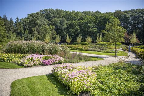 Overzicht van de kasteeltuinen met diverse bloemen en bomen