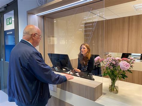 Illustratie van een reisadviseur die met een klant praat aan een balie in een modern reisbureau.