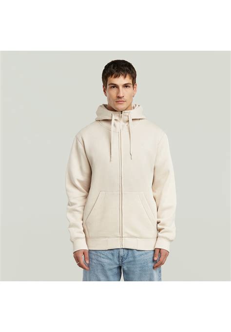 Detailfoto van een hoodie, met focus op de capuchon met trekkoord en de geribbelde boorden.