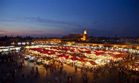 Een levendig Djemaa el Fna plein met straatartiesten en eetkraampjes bij avond