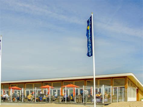 Gezellige strandtent met terras aan het strand van Katwijk aan Zee, met op de achtergrond de Noordzee.