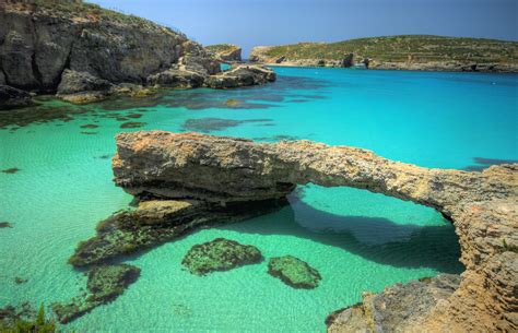 De turquoise wateren van de Blue Lagoon op Comino, met rotsformaties en boten.