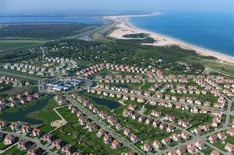 Luchtfoto van Noordzee Résidence De Banjaard met zicht op de villa's, het strand en de zee.