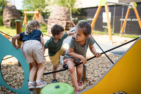 Foto van kinderen die buiten spelen in een park met speeltoestellen